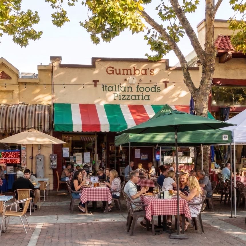 Gumba’s patio on Murphy Avenue, full of diners under green umbrellas